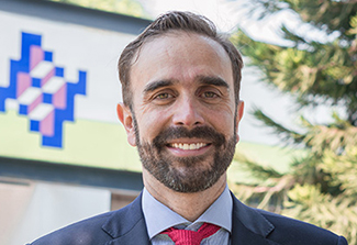 The photo shows Dr. Martin Lajous wearing a navy suit, blue shirt and red tie.